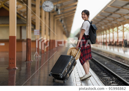 Young traveler woman looking for friend planning trip at train station. Summer and travel lifestyle concept. 91998862