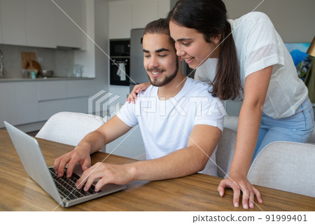 Content couple using laptop together 91999401