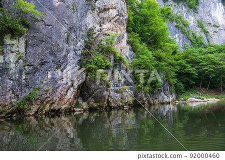 The green of the trees is reflected on the surface of the river and the beautiful clear stream Geibikei descends 92000460