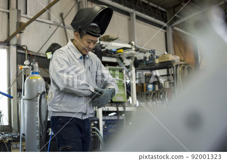 Male worker preparing with welding gloves in the factory 92001323