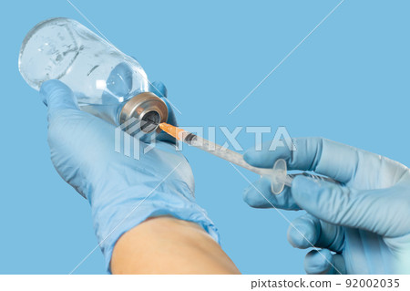 Plastic syringe and bottle for liquid medicine in hands. 92002035
