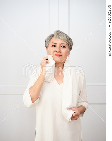 Portrait of mature 50s Asian woman wearing sports towel after exercise Portrait of mature 50s Asian woman wearing sports towel after exercise 92002239