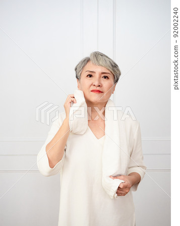 Portrait of mature 50s Asian woman wearing sports towel after exercise 92002240
