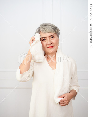 Portrait of mature 50s Asian woman wearing sports towel after exercise Portrait of mature 50s Asian woman wearing sports towel after exercise 92002243