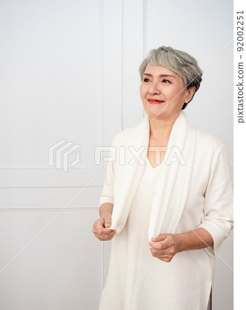 披著運動毛巾的成熟50多歲亞洲女人運動後的肖像 92002251