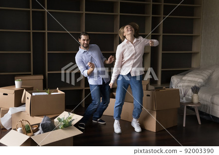 Cheerful happy young married couple moving into first home Cheerful happy young married couple moving into first home 92003390