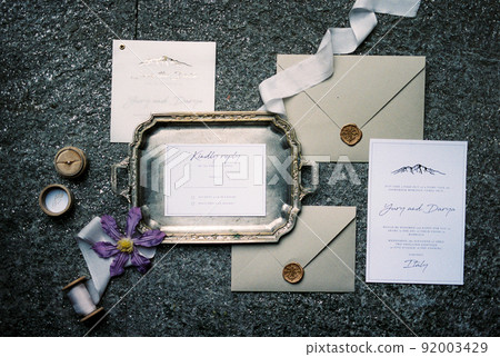Wedding invitations lie next to envelopes and a tray Wedding invitations lie next to envelopes and a tray 92003429