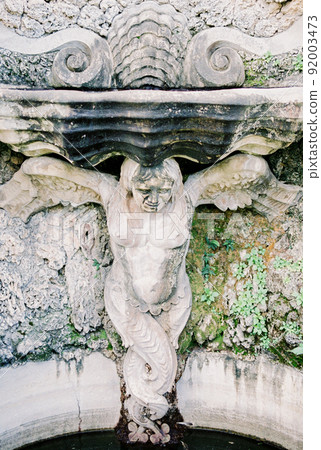 Stone sculpture of a mermaid at the fountain. Close-up 92003473