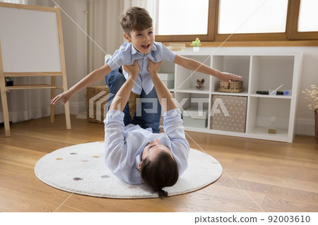 Strong father holding boy in air, lifting excited little son 92003610