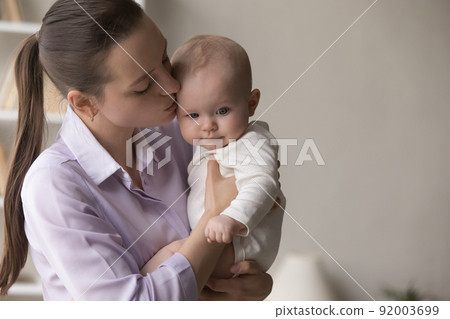 Young loving mother kissing her sweet baby, close up shot Young loving mother kissing her sweet baby, close up shot 92003699
