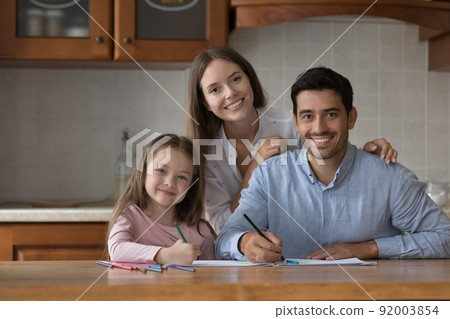 Parents and daughter drawing with pencils smile look at camera Parents and daughter drawing with pencils smile look at camera 92003854