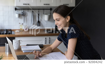 Happy busy freelance employee making video call on laptop Happy busy freelance employee making video call on laptop 92004242