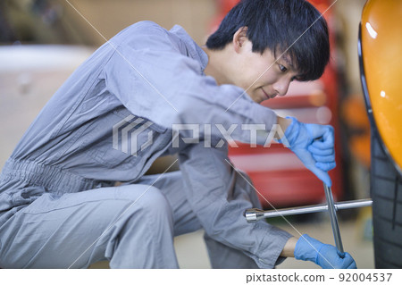 Auto mechanic working in a factory Auto mechanic working in a factory 92004537