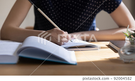 Young student girl preparing for college test, exam, writing notes 92004582