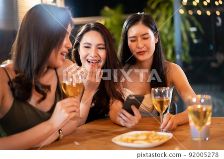 Happy Asian women enjoy celebrating a new year eve festival together with a lot of drink and food. New Year Eve party concept. Happy Asian women enjoy celebrating a new year eve festival together with a lot of drink and food. New Year Eve party concept. 92005278