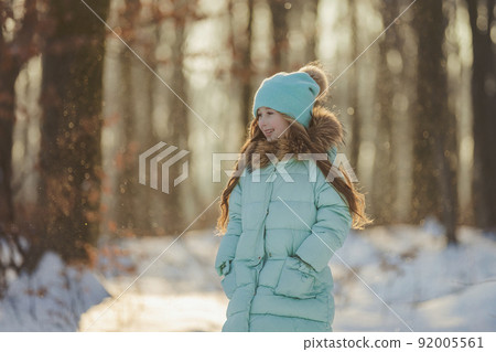 girl in the winter forest and turquoise-colored clothes girl in the winter forest and turquoise-colored clothes 92005561