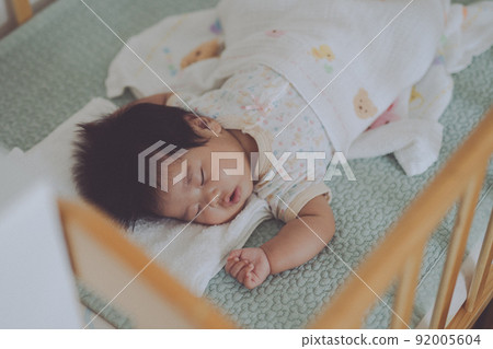 一個在嬰兒床上睡得很好的嬰兒 92005604