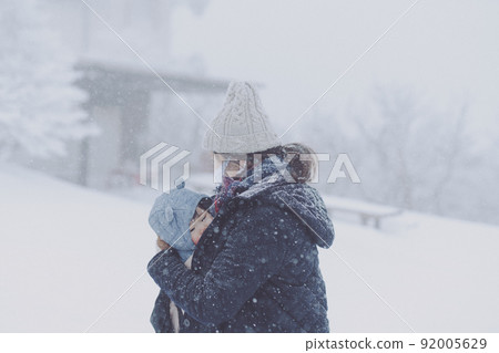 Parent and child in the snow of a blizzard Parent and child in the snow of a blizzard 92005629