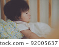 Profile of the baby peeking from the crib 92005637