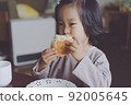 Girl chewing bread at home 92005645