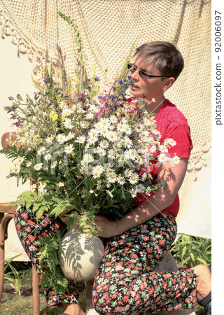 florist at work - portrait of a woman with a bouquet of wild flowers 92006097