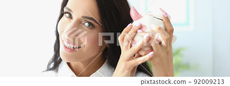 Woman person shake piggybank in hope to get money of it 92009213