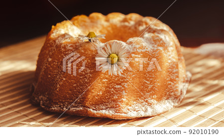 Cupcake decorated chamomile flower In the rustic style. Authentic photo. Easter concept greeting card background. Sun rays Homemade baked concept. Summer, Spring time recipe 92010190