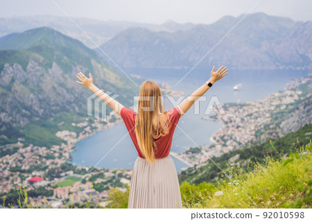 Woman tourist enjoys the view of Kotor. Montenegro. Bay of Kotor, Gulf of Kotor, Boka Kotorska and walled old city. Travel to Montenegro concept. Fortifications of Kotor is on UNESCO World Heritage Woman tourist enjoys the view of Kotor. Montenegro. Bay of Kotor, Gulf of Kotor, Boka Kotorska and walled old city. Travel to Montenegro concept. Fortifications of Kotor is on UNESCO World Heritage 92010598