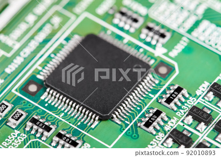 Close-up of a green computer printed circuit board with selective focus on a chip 92010893