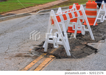 Pothole repair on damaged asphalt, with a carriageway to bypass the area where the repair 92011574
