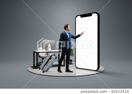 Young man, businessman standing in front of 3d model of cellphone with blank white screen isolated on grey background. Online shopping, payment, new app or website, Young man, businessman standing in front of 3d model of cellphone with blank white screen isolated on grey background. Online shopping, payment, new app or website, 92013418