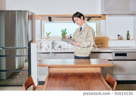 一位身著工作服的推銷員在廚房前做筆記 一位身著工作服的推銷員在廚房前做筆記 92014230