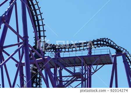 Lilac roller coaster against the blue sky. Extreme attraction in the amusement park Lilac roller coaster against the blue sky. Extreme attraction in the amusement park 92014274