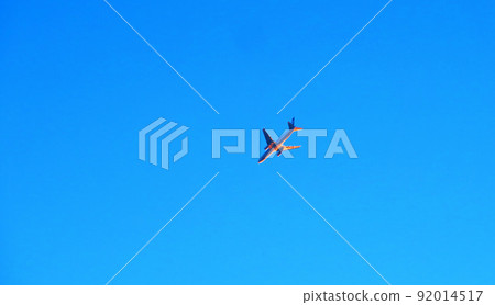 Scenery of an aircraft flying in the blue sky lit by dusk light Scenery of an aircraft flying in the blue sky lit by dusk light 92014517