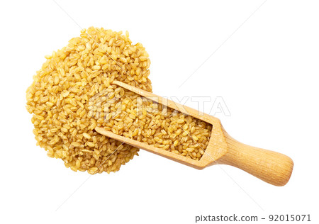 wooden spoon or scoop with raw bulgur isolated on white background top view. 92015071