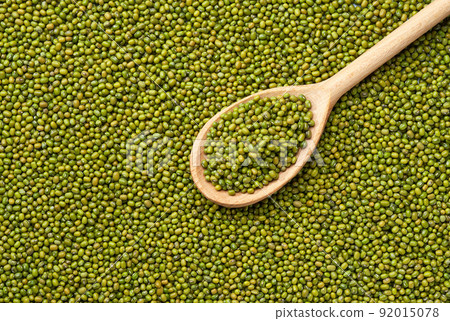 wooden spoon with raw mung beans on a mung beans background close-up top view. wooden spoon with raw mung beans on a mung beans background close-up top view. 92015078