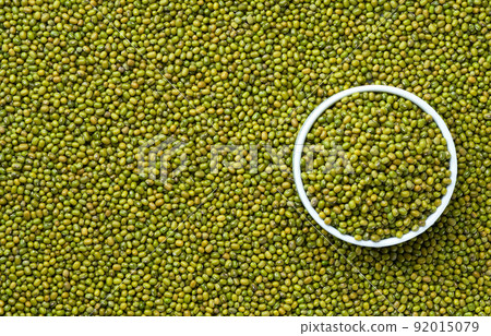ceramic plate with raw mung beans on a mung beans background close-up top view. ceramic plate with raw mung beans on a mung beans background close-up top view. 92015079