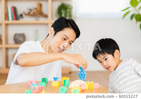 Children and fathers playing with alphabet blocks 92015227