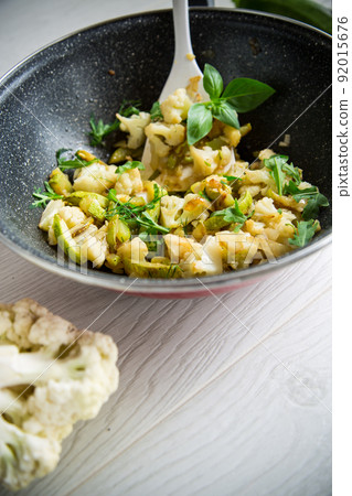 cauliflower fried with zucchini and vegetables in a pan cauliflower fried with zucchini and vegetables in a pan 92015676