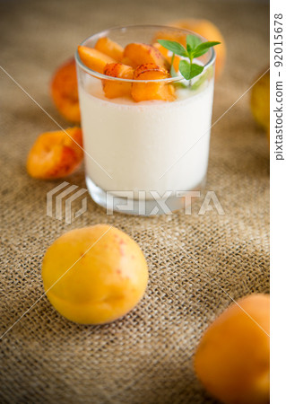 Healthy breakfast of homemade yogurt in a glass with fresh apricots 92015678
