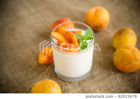 Healthy breakfast of homemade yogurt in a glass with fresh apricots 92015679