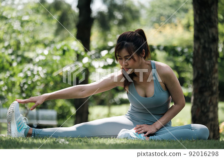 Young woman working out in park. 92016298