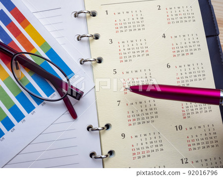 Business image of graphs, glasses, calendars, notebooks (female) Business image of graphs, glasses, calendars, notebooks (female) 92016796