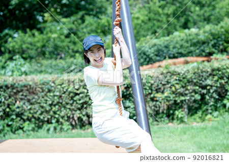Active women playing with the Tarzan rope of the playset Active women playing with the Tarzan rope of the playset 92016821