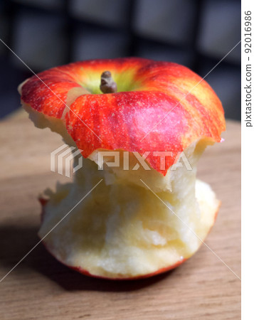 A bitten red apple, close-up shot. Apple core. A bitten red apple, close-up shot. Apple core. 92016986