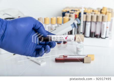 Researcher with blood sample of New Variant of the Covid-19 DELTACRON and generic data of covid-19 Coronavirus Mutations. Doctor in analysis lab holding sample of new strain of covid DELTACRON. Researcher with blood sample of New Variant of the Covid-19 DELTACRON and generic data of covid-19 Coronavirus Mutations. Doctor in analysis lab holding sample of new strain of covid DELTACRON. 92017495