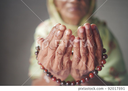 Close up of senior women hand praying at ramadan  92017891