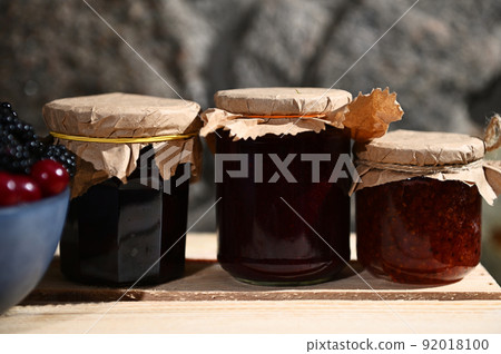 Collection of homemade jam from red currant, cherries and blackcurrant on a wooden surface. Canned food, canning concept Collection of homemade jam from red currant, cherries and blackcurrant on a wooden surface. Canned food, canning concept 92018100