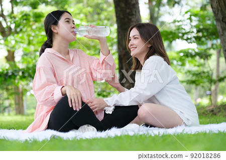 Pregnant woman with her friends drinking water Pregnant woman with her friends drinking water 92018286