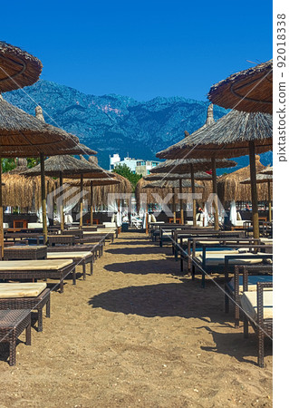 View of deck chairs and umbrellas on the sandy beach of Kemer, Turkey. 92018338